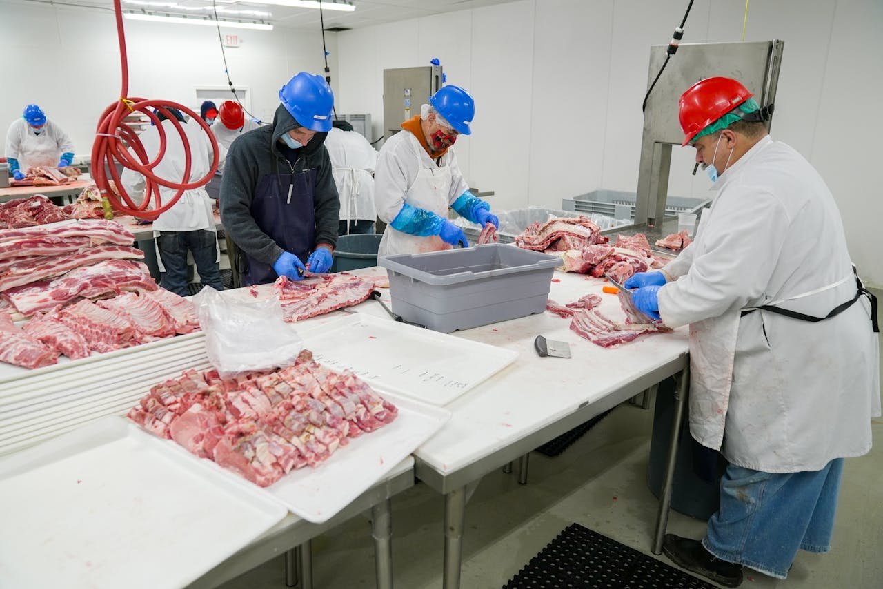 service-02 Butchers expertly processing meat in a USDA-inspected facility. Hygiene and precision are prioritized.